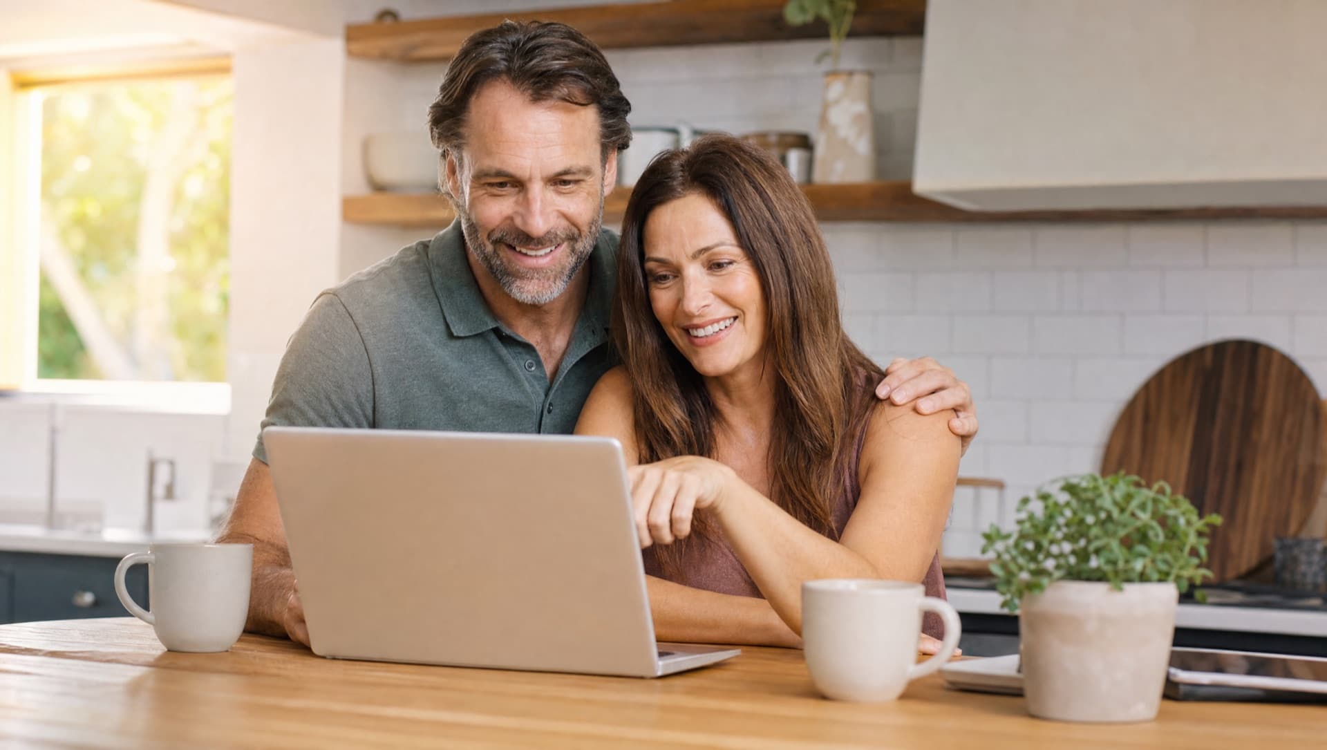 A couple reviewing a dental implant plan together at a kitchen island